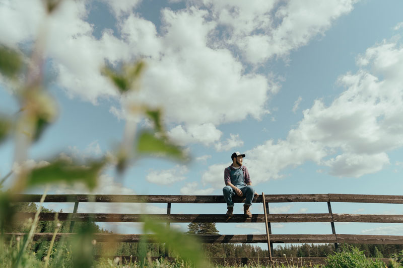 Farmer sits on a fence